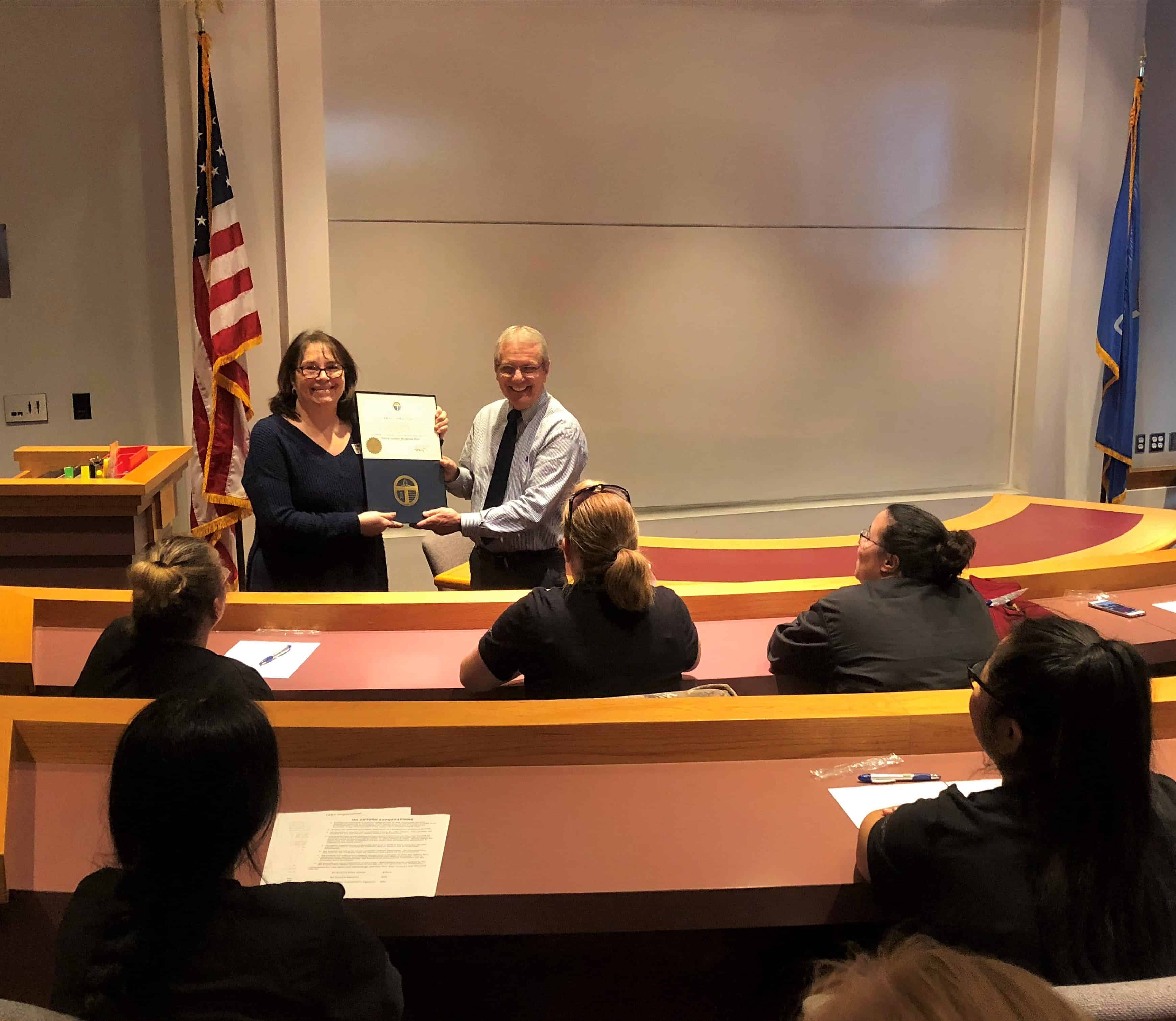 Medical assistants watch as Community Care College in Tulsa is issued a certificate from Tulsa Mayor G. T. Bynum