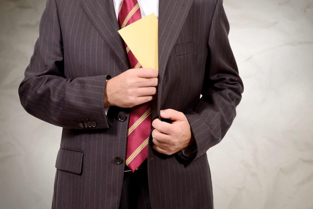 A closeup of a businessman in a suit holding a folder